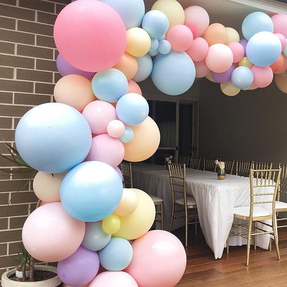 pastel macaron rainbow arch on display with table setting background