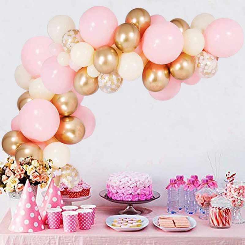 pink and gold confetti balloon arch in background of party table setup