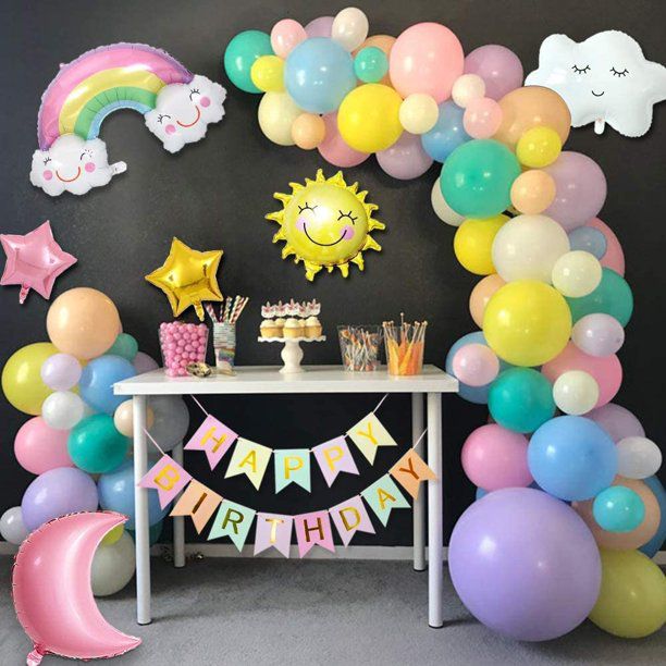 rainbow cloud happy birthday on black wall display with table and toppings